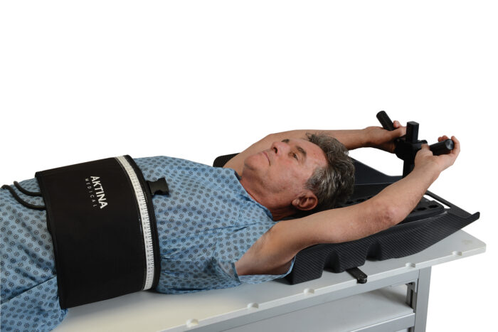 Man lying on SBRT board with ArmCradle 4 Y handle and compression belt