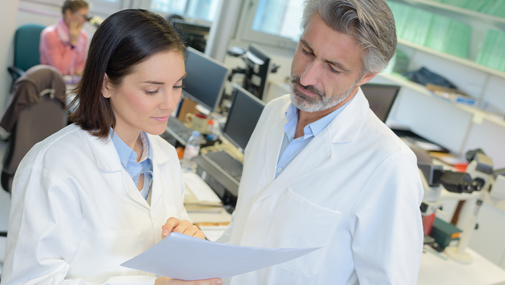 Female and male therapist discussing paperwork